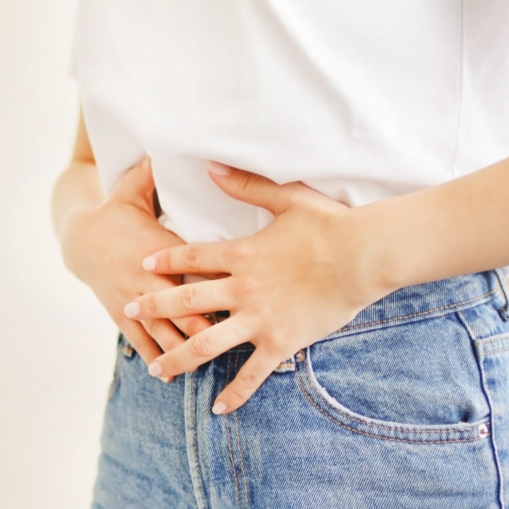 Woman suffering from stomach ache. Holding belly and feeling abdominal menstrual pain or bowel and digestion problems