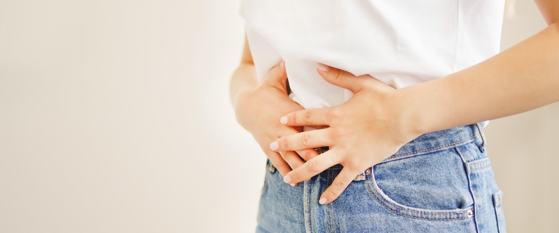 Woman suffering from stomach ache. Holding belly and feeling abdominal menstrual pain or bowel and digestion problems