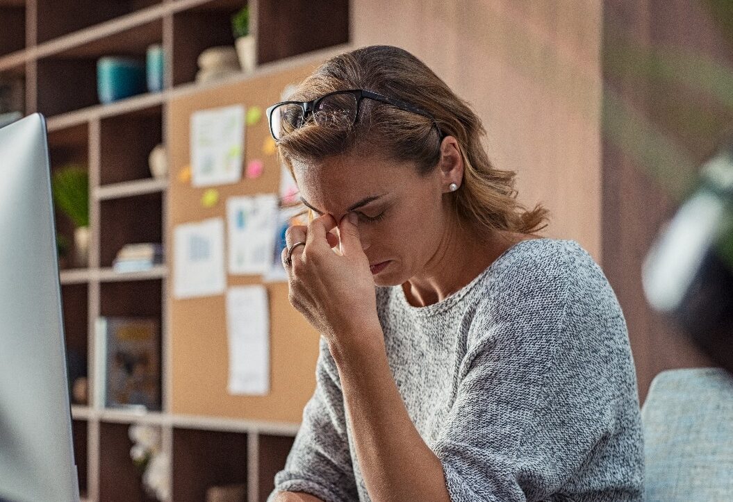 Geschäftsfrau mit Kopfschmerzen im Büro